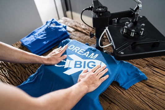 Custom Apparel Ordering Process Made Simple with a blue T-shirt being printed using a heat press machine.