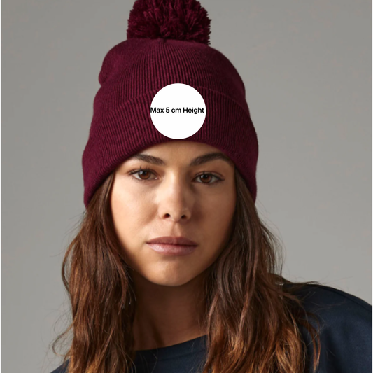 Custom Embroidered Pom Pom Beanie in burgundy color, featuring a fluffy top pom pom, ideal for keeping warm this winter.